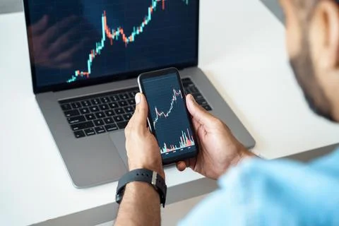 Closeup view on mobile phone analytics app and laptop statistics graph software Stock Photos