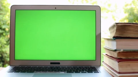 Closeup view of modern green screen laptop with old books on the table with Stock Footage 114129807