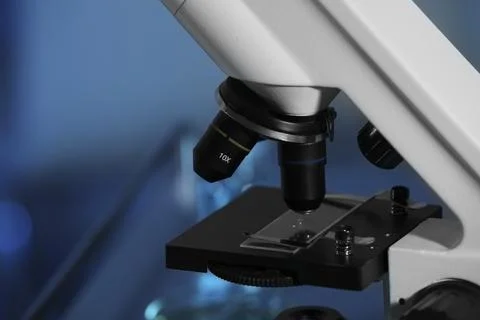 Closeup view of modern microscope with glass slide on blurred background, t.. Stock Photos