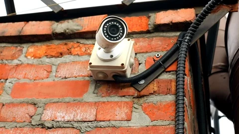 Closeup view of modern privacy CCTV camera outside with brick wall on background Vídeos de archivo 116776973