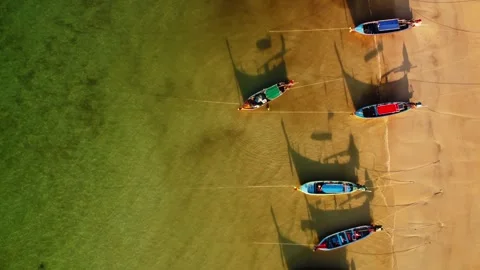 Closeup view of moored boats casting shadows onto clear shallow water with Stock Footage 344086621