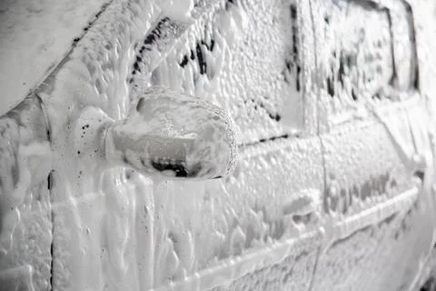 Closeup view of motor car with solid layer of soap sud during car wash. 写真素材