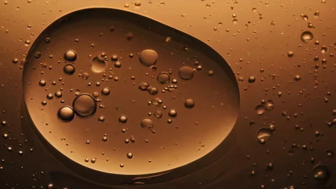 Closeup view of numerous Bubbles floating in a rich Amber Liquid, creating Stock Footage 305830748
