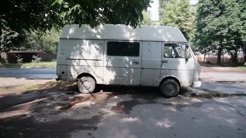 Closeup view of old rusty white abandoned car minivan standing in the street. Stock Footage 157101657