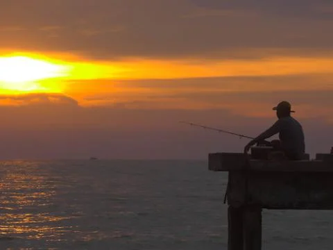 Closeup view peaceful beach with unidentified people during sunset. Photos