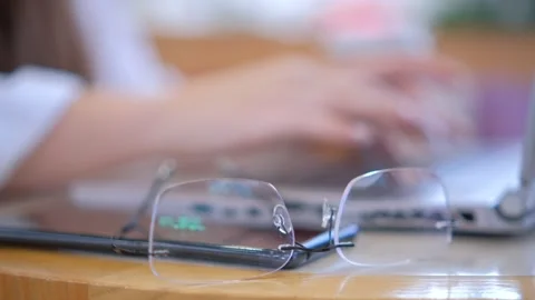 A closeup view of a person focused on work, typing on a laptop while wearing Stock Footage 276489884