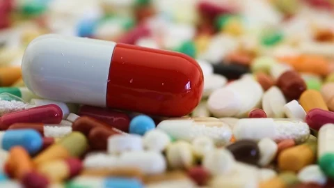Closeup view of pills spinning with large one in center Stock Footage 95913193