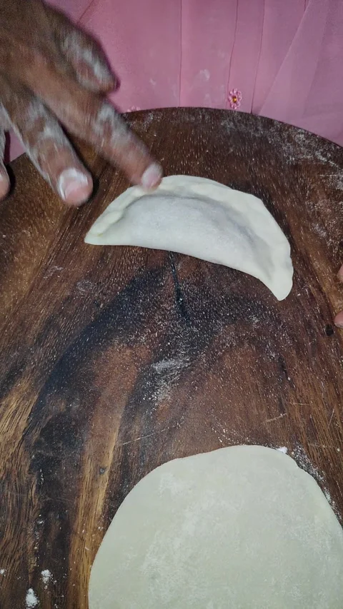 Closeup view of preparing traditional Indian sweet dumpling shaped puri by ha Stock Footage 339080650