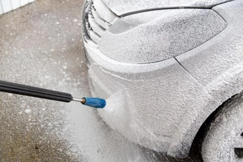 A closeup view of process of indoor wet car washing. Front side with headlamp. Stock Photos