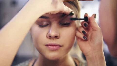 Closeup view of professional makeup artist's hands applying mascara on eye 動画素材 83165206