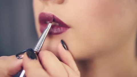 Closeup view of a professional makeup artist's hand using special brush to apply Stock Footage 83165500