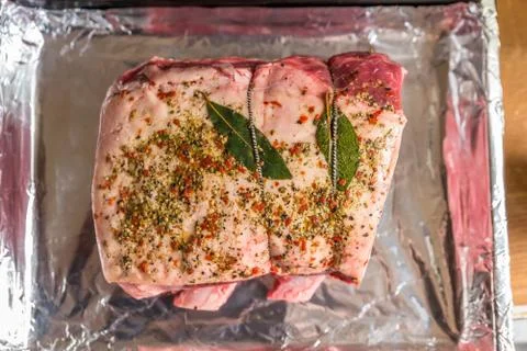 Closeup view raw beef cross rib chunk on oven tray with foil 库存照片
