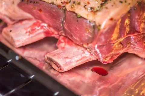 Closeup view raw beef cross rib chunk on oven tray with foil inside oven Stock-Fotos