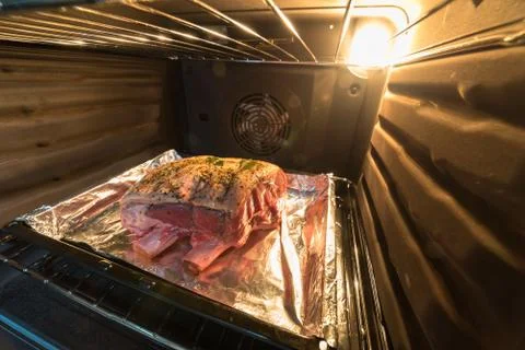 Closeup view raw beef cross rib chunk on tray with foil inside oven Stockfoto's