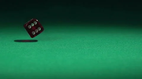 Closeup view of red casino dice rolling on green surface in slow-motion Stock Footage 62489546