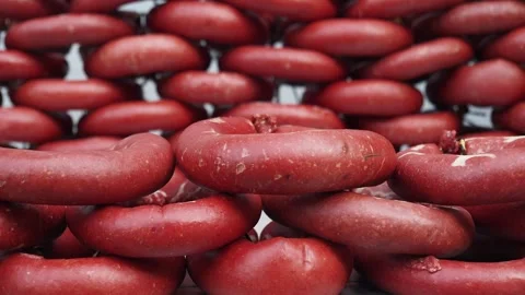 A CloseUp View of Red Doughnut Shaped Objects Carefully Stacked Together in an Vídeos de archivo 290285519