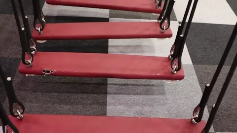 A closeup view of a red swing set situated on modern, stylish flooring surfaces Stock Footage 295814948