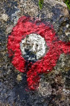 Closeup view of a red trail marker sign on the stone surface on the ground Stock Photos