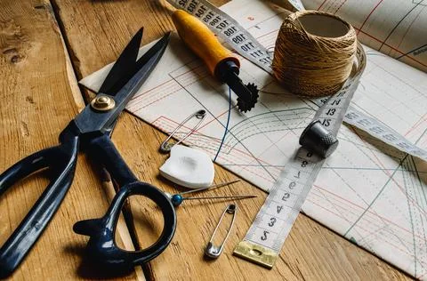 Closeup view of retro sewing tools, scissors, chalk, measuring tape lie on ta Stock Photos