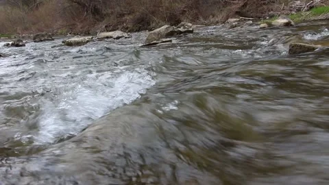 Closeup view of the river stream that flows rapidly with stones in background Video stock 153765867