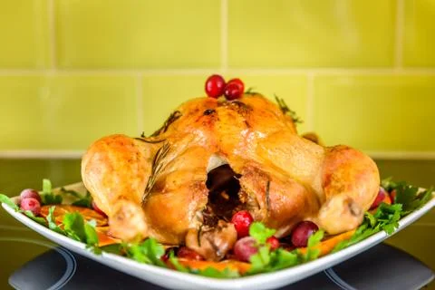 Closeup view of roasted chicken on white plate on kitchen table 스톡 사진