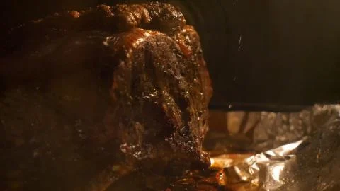 Closeup view roasting beef joint on foil covered tray cooking inside oven for Stock-Fotos