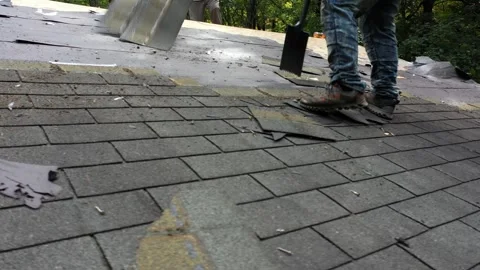 Closeup view of roofer removing old roof shingles to be replaced with new roof Stock Footage 252372107