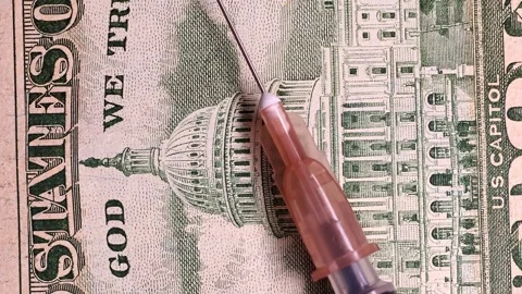 Closeup view of rotating syringe and brand new 50 USD american dollars banknote. Stock Footage 297244321