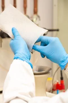 Closeup view of a scientist removing a sample from a packet inside a laborato 스톡 사진