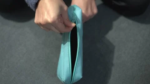 A closeup view showcasing hands gently using a beautifully designed zippered Stock Footage 318544480