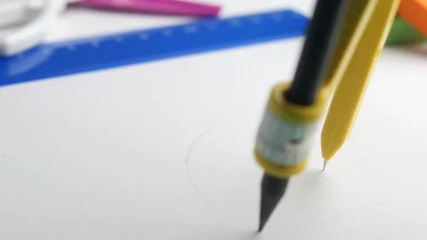 A CloseUp View Showing a Compass and Pencil Placed on Blank Drawing Paper for Stock Footage 292945948