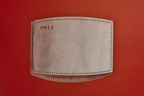 Closeup view of single white PM 2.5 filter on red reflective background Stock Photos