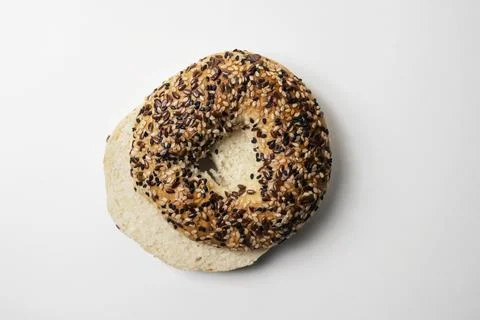 Closeup view of slice of bagel bread with sesame seeds isolated over white .. Stock Photos