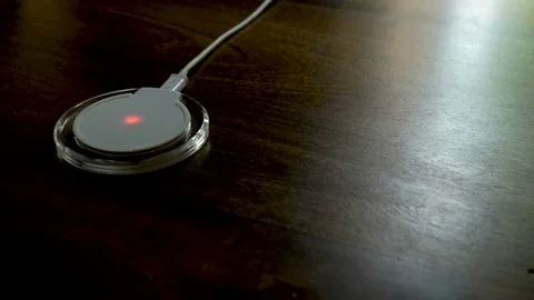 Closeup view of smartphone charging on a charging pad Vídeos de archivo 77224471