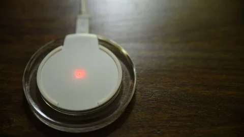 Closeup view of smartphone charging on a charging pad Vídeos de archivo 77318218