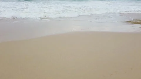 Closeup view of soft waves of blue tropical ocean washes shore of sandy beach Stock Footage 138265187