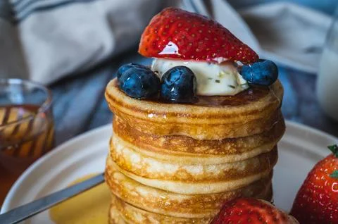 Closeup view of Stack of pancakes with honey, strawberry, blue berry and wh.. Stock Photos