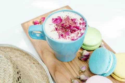 Closeup view on straw hat and blue cup of aroma cappuccino with french tasty  Stock Photos