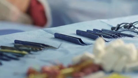 Closeup view of a surgeon's hand which is wearing a rubber glove picking up a Video stock 134701659