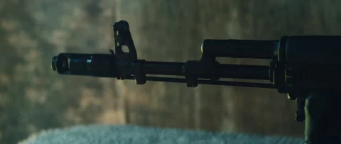 Closeup view of tactical rifle muzzle emits flash and smoke during firing at Stock Footage 310237364