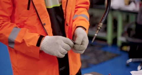Closeup view of technician hand in glove holding robotic welding tool during Stock Footage 313646984