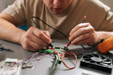 Closeup view of technician repairing electronics, inspecting and testing circuit 스톡 사진