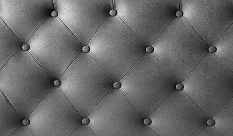 Closeup view of textured gray leather upholstery with elegant tufting. Blac.. Stock Photos