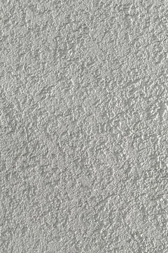 Closeup view of textured plaster surface with an uneven relief pattern. Gra.. Stock Photos