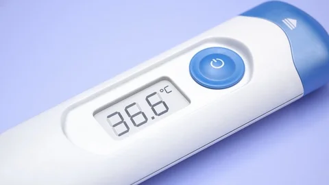 Closeup view at a thermometer with rising temperature value. Pills. Fever. 4KHD Stock Footage 119989435