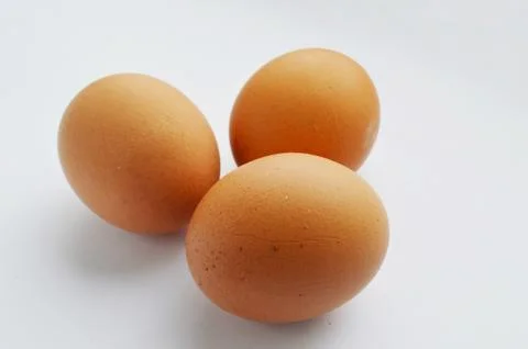 Closeup view of three brown eggs isolated on the white. Stock Photos