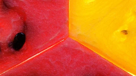 Closeup view of three slices of red and yellow watermelon rotating in 4K Vidéo 85607196