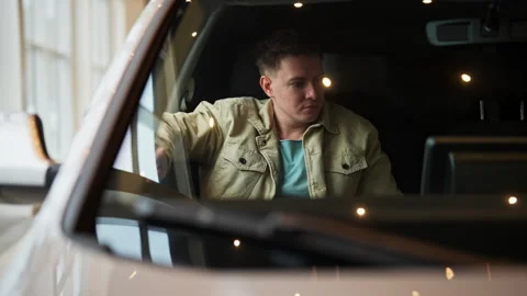 Closeup view through windshield of confident male customer fastening seat belt Stock Footage 278242567