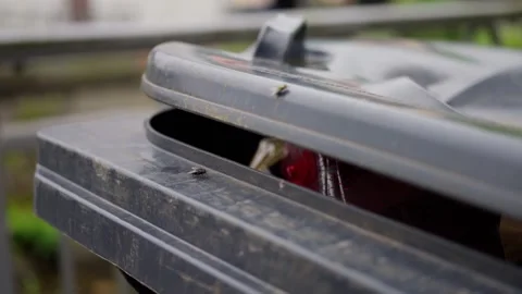 A CloseUp View of a Trash Bin Lid Being Opened Outdoors in a City Environment Stock Footage 305325981