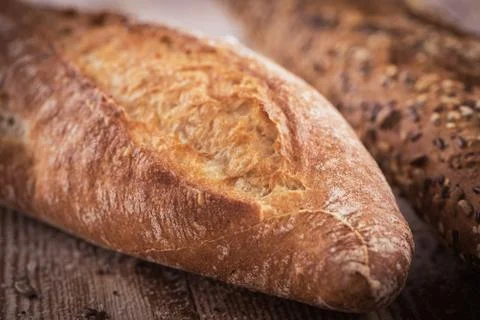 Closeup view of two fresh crunchy baguettes with sunflower seeds and other se Stock Photos